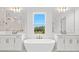 Bright bathroom featuring dual sink vanities, a soaking tub, and a beautiful view of the backyard at 33736 Ocean Spray Ln, Wesley Chapel, FL 33543