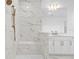 Luxurious walk-in shower with marble tile, a built-in bench, and bronze shower fixtures at 33736 Ocean Spray Ln, Wesley Chapel, FL 33543