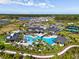 Aerial view of community pool and clubhouse surrounded by lush tropical landscaping at 33736 Ocean Spray Ln, Wesley Chapel, FL 33543