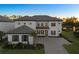 Elegant two-story home with a tile roof, a well-manicured lawn, and a paved driveway leading to a two-car garage at 33736 Ocean Spray Ln, Wesley Chapel, FL 33543