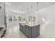Bright, open kitchen with a large island, modern lighting, and expansive windows overlooking the backyard at 33736 Ocean Spray Ln, Wesley Chapel, FL 33543
