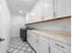 Modern laundry room with new washer, dryer, storage cabinets, and stylish tile flooring at 33736 Ocean Spray Ln, Wesley Chapel, FL 33543