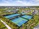 Aerial view of community tennis courts surrounded by lush tropical landscaping at 33736 Ocean Spray Ln, Wesley Chapel, FL 33543