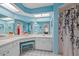 Bright bathroom features a double vanity and shower with floral curtain at 3948 Tarpon Pointe Cir, Palm Harbor, FL 34684