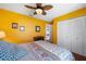 Bright bedroom with closet and colorful bedding, plus ceiling fan and attached bathroom at 3948 Tarpon Pointe Cir, Palm Harbor, FL 34684