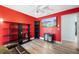 The bedroom is red with wood flooring, a black shelf, and a television at 3948 Tarpon Pointe Cir, Palm Harbor, FL 34684