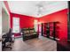 The bedroom has red walls, a dark couch, and a black shelf at 3948 Tarpon Pointe Cir, Palm Harbor, FL 34684