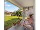 Cozy front porch with comfortable seating, potted plants, and view of the landscaped front yard at 3948 Tarpon Pointe Cir, Palm Harbor, FL 34684
