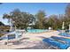 Relaxing community pool with ample seating, umbrellas, and lush landscaping on a sunny day at 3948 Tarpon Pointe Cir, Palm Harbor, FL 34684