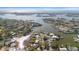 Picturesque aerial view of waterfront properties with boat docks, lush greenery, and sparkling ocean backdrop at 4036 Church Creek Pt, Largo, FL 33774