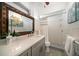 Well-lit bathroom featuring a shower, toilet, and vanity with decorative mirror and a neutral color scheme at 4036 Church Creek Pt, Largo, FL 33774