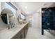 Luxurious bathroom with a double sink vanity, blue tiled shower, and modern fixtures at 4036 Church Creek Pt, Largo, FL 33774