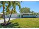 Charming single-story home showcasing a manicured lawn, tropical landscaping, and a two-car garage at 4036 Church Creek Pt, Largo, FL 33774