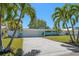 Inviting home featuring a well-maintained lawn, a spacious driveway, and mature palm trees at 4036 Church Creek Pt, Largo, FL 33774