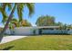 Single-story home with blue exterior, lawn, large tree, driveway, and an attached garage at 4036 Church Creek Pt, Largo, FL 33774