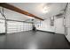 Spacious garage with an open door, white walls, gray floor, storage accessories, and functional lighting at 4036 Church Creek Pt, Largo, FL 33774