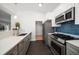 Modern kitchen boasts stainless steel appliances, gray cabinets, and sleek countertops at 4036 Church Creek Pt, Largo, FL 33774