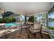Enclosed lanai with a covered seating area overlooks a pool and waterfront views at 4036 Church Creek Pt, Largo, FL 33774