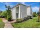 Bright two-story townhome featuring a private entrance, manicured lawn, and lush landscaping at 4201 La Palma Ct, Tampa, FL 33611