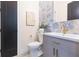 Chic powder room featuring a gray vanity, gold fixtures, and decorative blue tile backsplash at 526 39Th S Ave, St Petersburg, FL 33705