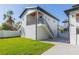 Two-story home with white siding, black trim, and outdoor staircase with a small front yard and paved driveway at 526 39Th S Ave, St Petersburg, FL 33705