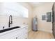 Functional laundry area with modern sink, sleek faucet, under cabinet storage, and water heater at 526 39Th S Ave, St Petersburg, FL 33705