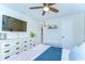 A cozy bedroom with a ceiling fan, dresser, and mounted television at 527 S Lincoln Ave # A108, Tampa, FL 33609