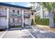 Two-story condo building with parking area and exterior stairs and balcony on a sunny day at 527 S Lincoln Ave # A108, Tampa, FL 33609