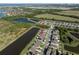 Aerial view of homes on a street with ponds, green spaces, and a view of the Gulf at 5425 Rainwood Meadows Dr, Apollo Beach, FL 33572