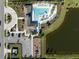 Aerial view of community pool, playground, parking lot, and pond surrounded by lush landscaping at 5425 Rainwood Meadows Dr, Apollo Beach, FL 33572