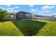 Expansive backyard with lush grass, screened-in patio, and a view of neighboring homes at 5425 Rainwood Meadows Dr, Apollo Beach, FL 33572