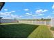 Spacious backyard featuring well-maintained grass and white fencing at 5425 Rainwood Meadows Dr, Apollo Beach, FL 33572