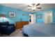 Tranquil bedroom featuring a ceiling fan, wood-look floors, and a comfortable armchair at 5425 Rainwood Meadows Dr, Apollo Beach, FL 33572
