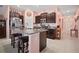 Kitchen showcasing dark brown cabinets, an island with seating, and stainless steel appliances at 5425 Rainwood Meadows Dr, Apollo Beach, FL 33572