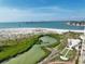 Scenic aerial shot of coastal waterfront featuring a sandy beach, lush green foliage, and sparkling blue waters at 755 Collany Rd # 504, Tierra Verde, FL 33715