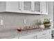 Wet bar with white cabinets, marble countertop and textured backsplash at 755 Collany Rd # 504, Tierra Verde, FL 33715