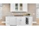 Wet bar with white cabinets, wine rack, marble countertop and glass display cabinets at 755 Collany Rd # 504, Tierra Verde, FL 33715