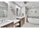 Bright bathroom featuring double vanity, soaking tub, and decorative fish accents at 755 Collany Rd # 504, Tierra Verde, FL 33715