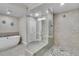 Spa-like bathroom featuring a stand-alone tub and a glass-enclosed shower with mosaic tiling at 755 Collany Rd # 504, Tierra Verde, FL 33715