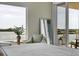 Beautifully decorated bedroom features a view of the water from the large window and sliding glass door at 755 Collany Rd # 504, Tierra Verde, FL 33715