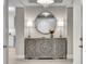 Elegant entryway with a carved console table, round mirror, and modern chandelier at 755 Collany Rd # 504, Tierra Verde, FL 33715