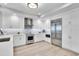 Modern white kitchen with stainless steel appliances, stone backsplash, and light wood flooring at 755 Collany Rd # 504, Tierra Verde, FL 33715