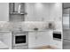 Contemporary kitchen with stainless steel appliances, white cabinetry, and stylish backsplash at 755 Collany Rd # 504, Tierra Verde, FL 33715