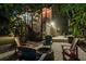 Inviting backyard featuring a stone fire pit and colorful Adirondack chairs surrounded by lush tropical landscaping at 758 Claudia Ln, Palm Harbor, FL 34683