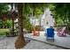 Inviting backyard features a tiki hut, firepit, colorful Adirondack chairs and lush landscaping at 758 Claudia Ln, Palm Harbor, FL 34683