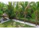 An inviting backyard features lush landscaping and a charming tiki hut with a seating area at 758 Claudia Ln, Palm Harbor, FL 34683