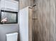 Features a stand-up shower stall with decorative gray wavy wall tiles and a toilet with a flamingo decoration at 758 Claudia Ln, Palm Harbor, FL 34683