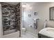 Contemporary bathroom boasts black and gray brick tile shower with tub, patterned floor tiles, and modern vanity at 758 Claudia Ln, Palm Harbor, FL 34683