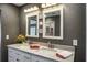 Double sink vanity with white cabinets, granite counters, stylish mirrors, and contemporary lighting fixtures enhance this bathroom at 758 Claudia Ln, Palm Harbor, FL 34683