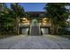 Charming two-story home with a spacious porch, two-car garage, and mature trees at twilight at 758 Claudia Ln, Palm Harbor, FL 34683